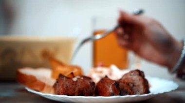 Bira ve patatesin arka planında kebap.