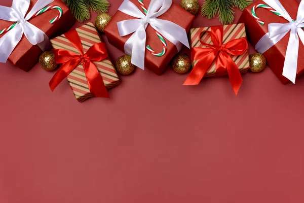 Kırmızı arka plan, hediyeler, Noel süsleri ve baston şekerler. Mesaj için yer. Xmas yatıyordu. Kopyalama. Kimse..