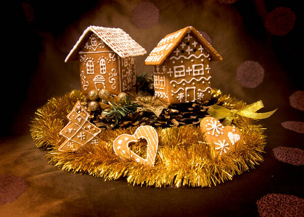 Натюрморт с рождественскими пряничными домиками, печеньем и новогодней мишурой на обычном фоне