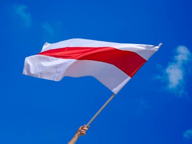 Mavi gökyüzü arka planında bulutlu Belarus ulusal bayrağını dalgalandırmak. Beyaz-kırmızı-beyaz bayrak hazır. Beyaz Rusya 'da cumhurbaşkanlığı seçimlerinden sonra diktatörlüğe karşı yapılan barışçıl protestoların sembolü..