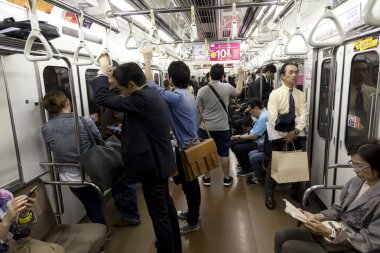 Tokyo - Circa Mayıs, 2016: Tokyo metro ile seyahat yolcu. Acele saat içinde toplu taşıma araçları ile çalışmaya commuting işadamları. Sığ derinliği alan fotoğraf