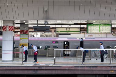 Tokyo, Japonya - 19 Mayıs: 19 Mayıs 2016'da Tokyo istasyonunda, oncomming trenine eğilen tren servis personeli.