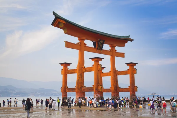 MIYAJIMA, JAPÓN - 27 DE MAYO: Los turistas caminan alrededor de la famosa puerta torii flotante del Santuario de Itsukushima en Miyajima durante la marea baja mostrada el 27 de mayo de 2016 en Miyajima, Japón — Foto de Stock