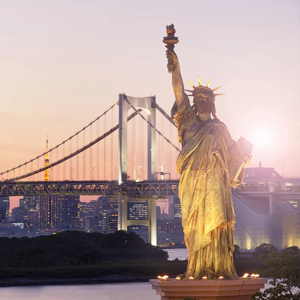 Tokyo skyline kritisera solnedgång, Frihetsgudinnan och Rainbow Bridge med stadsbilden på Odaiba Island, Japan — Stockfoto