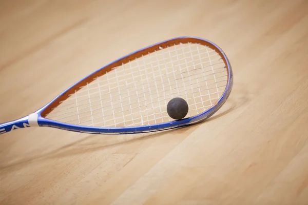Primer plano de una raqueta de squash y pelota sobre fondo de madera — Foto de Stock