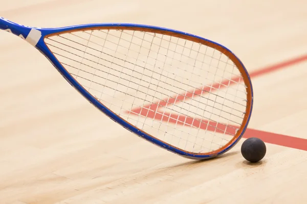 Primer plano de una raqueta de squash y pelota sobre fondo de madera —  Fotos de Stock