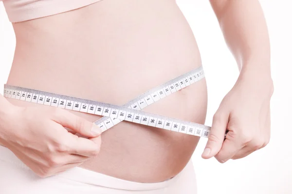 Bauch einer Schwangeren mit Maßband — Stockfoto