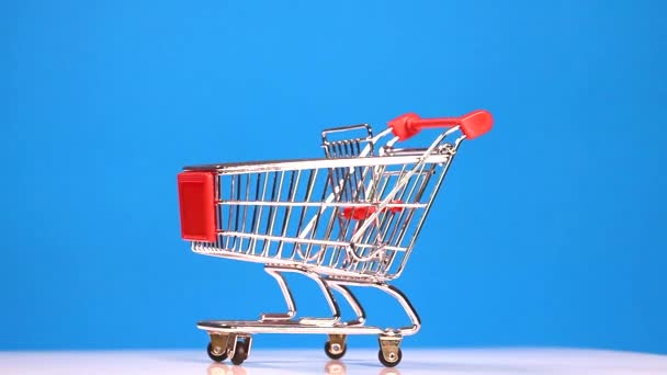 Carrello shopping su sfondo blu — Video Stock