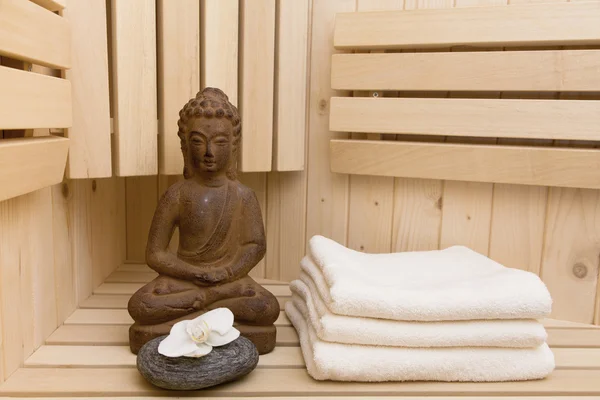 Symboles ayurvédiques pour la détente et la beauté intérieure, statue de bouddha dans le sauna — Photo