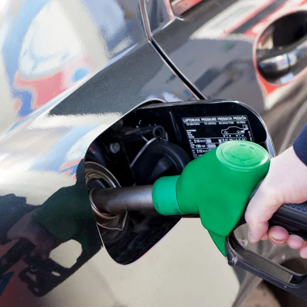 Homem enchendo carro com combustível no posto de gasolina — Fotografia de Stock