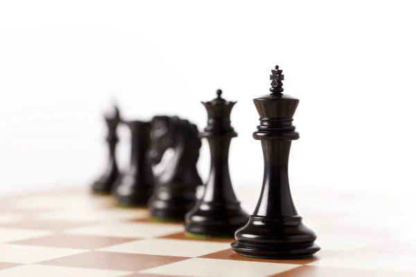 Black chess pieces on a chessboard standing in perspective — Stock Photo, Image