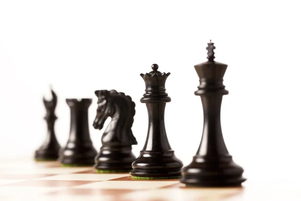 Czarne bierki na szachownicy stojący w perspektywie — Zdjęcie stockowe