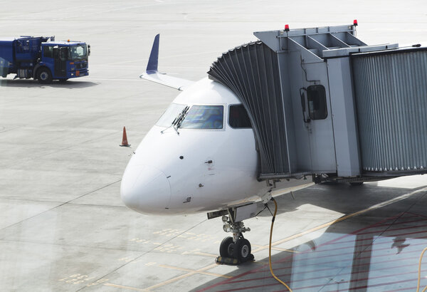 Gangway attached to plane in airport at daytime 