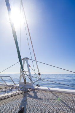 katamaran yelkenli. Sakin mavi okyanus ve Bulutsuz mavi gökyüzü arka planda vardır