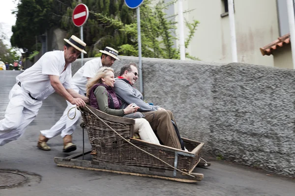 Funchal, Madeira - 20 mei: Traditionele afdaling slee reis op 20 mei 2015 in Madeira, Portugal. Slee werden gebruikt als plaatselijk vervoer. Op dit moment zijn deze rodelbaan renners een toeristische trekpleister — Stockfoto