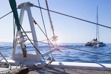 katamaran yelkenli. Sakin mavi okyanus ve Bulutsuz mavi gökyüzü arka planda vardır