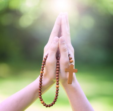 Christian prayer beads in the hand of woman clipart