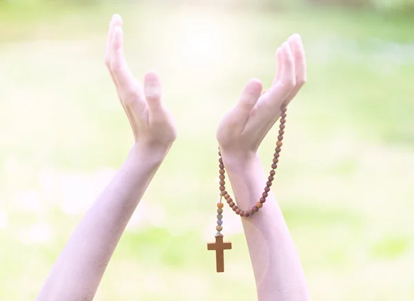 Rosary in hands, religious background — Stock Photo, Image