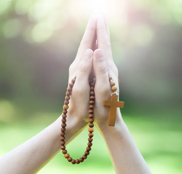 Hand holding wooden rosary beads in close up — Stock Photo, Image