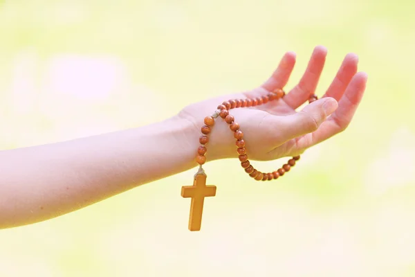 Rosary in hands — Stock Photo, Image