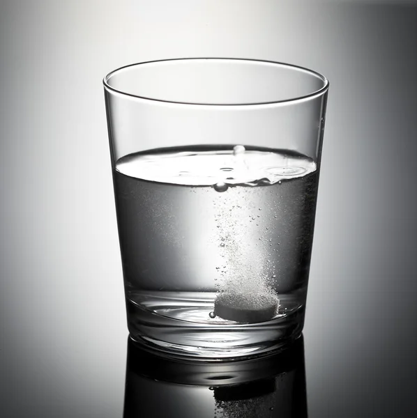 Glas met bruistablet in water — Stockfoto