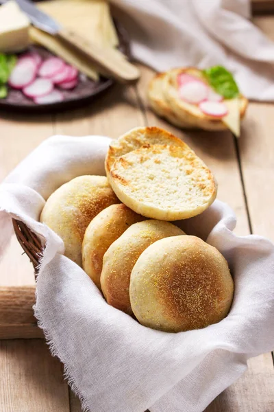 English muffins from whole grain and flax meal, filed with cheese and radish. Rustic style.