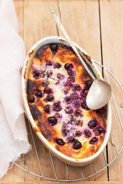 Ahşap bir yüzey üzerinde seramik formda üzümlü kaymak güveci..