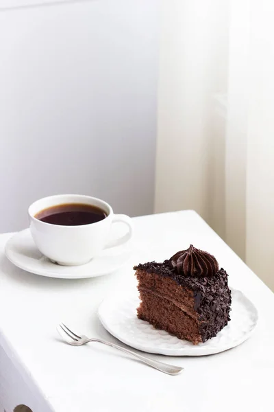 Chocolate cake and coffee, still life in a light interior. — Stock Photo, Image