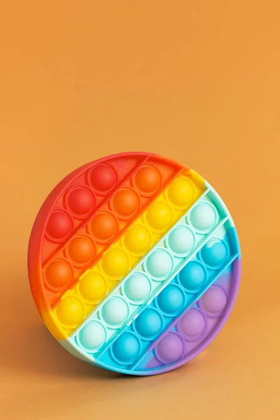 Beliebtes Spielzeug Pop it Antistress Regenbogenfarben, aus Silikon. Stockbild