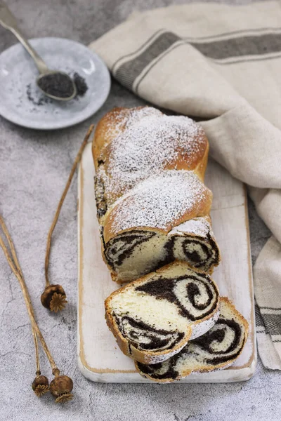 Kuchen mit Mohnfüllung und Saatköpfen auf grauem Betongrund. Rustikaler Stil. — Stockfoto