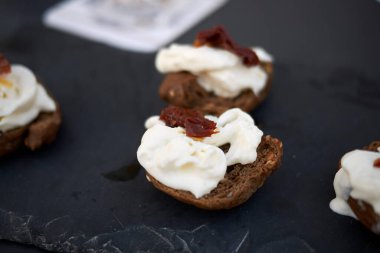 Burrata peyniri ve kurutulmuş domatesli tam tahıllı frisella.