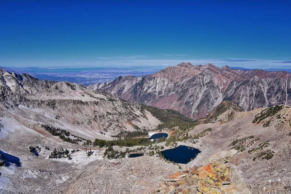 Red Pine Lake mountain landscape scenic view from White Baldy and Pfeifferhorn hiking trail, towards Little Cottonwood Canyon, Wasatch Rocky mountain Range, Utah, United States.