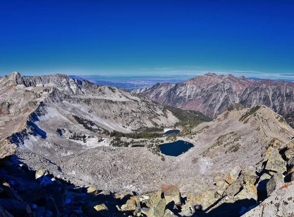 Red Pine Lake mountain landscape scenic view from White Baldy and Pfeifferhorn hiking trail, towards Little Cottonwood Canyon, Wasatch Rocky mountain Range, Utah, United States.