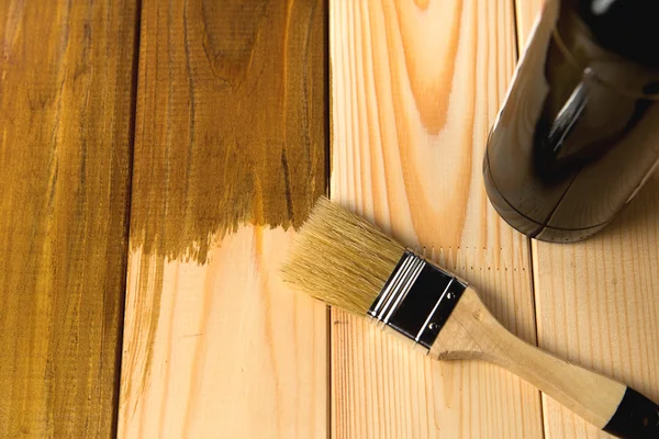 Process of painting the wood boards with the brush and the bottl Royalty Free Stock Photos