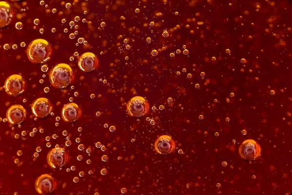 Makroblase und Schaum an der Glaswand der Cola Stockbild