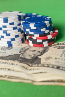 dolar ve yeşil bir masada poker fişleri