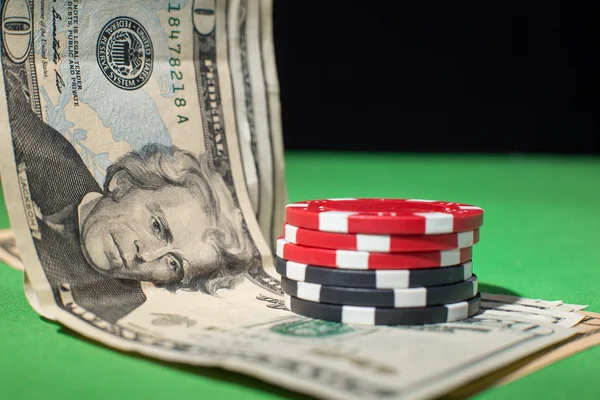 dolar ve yeşil bir masada poker fişleri