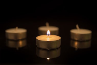 Siyah yansıma ile dört çay mumlar