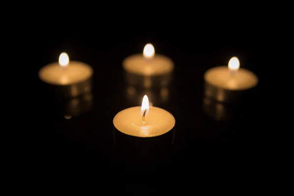 Four Tea Candles with Reflection on Black — Stock Photo, Image