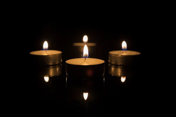 Four Tea Candles with Reflection on Black — Stock Photo, Image