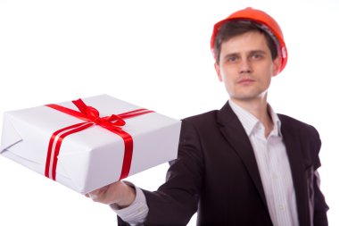 kask elbiseli adam kırmızı ile beyaz hediye kutusu verir