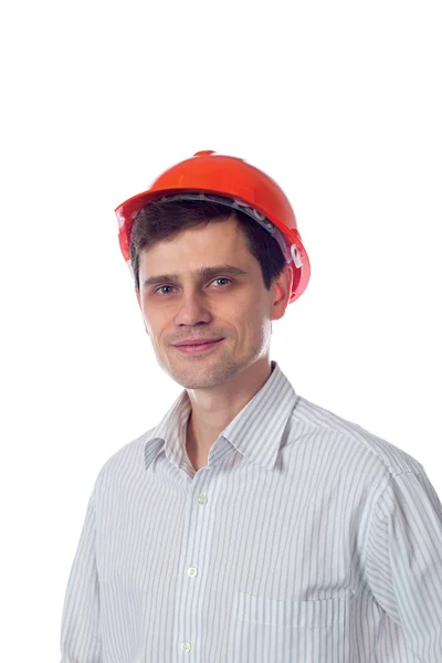 Glimlachende man in een oranje shirt bouw helm isolaat — Stockfoto
