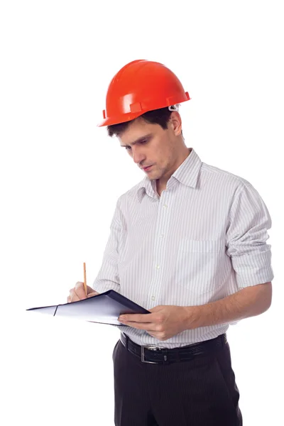 Man in een shirt oranje bouw helm schrijft zwarte map — Stockfoto