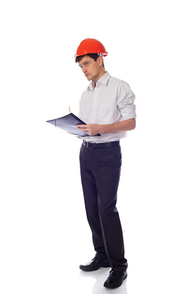 Man in a shirt orange construction helmet writes black folder — Stock Photo, Image