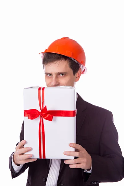 Man in a helmet suit gives gift white box with red — Stock Photo, Image