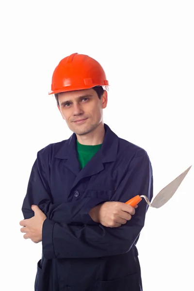 Man in een helm en een blauw gewaad bedrijf gebouw Troffel wapens vouwen — Stockfoto