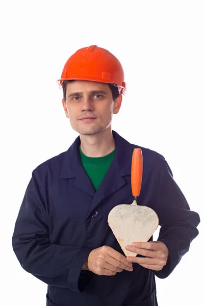 Man in een helm en een blauw gewaad bedrijf gebouw Troffel hart-conf — Stockfoto