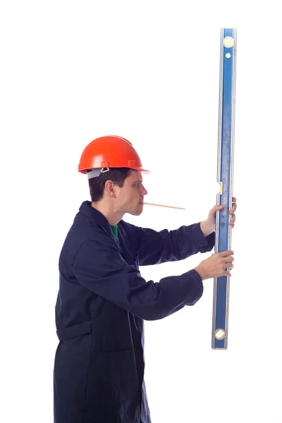 Hombre con casco y bata azul que sostiene el nivel del edificio, pensil — Foto de Stock