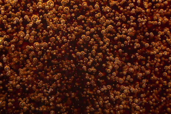 Macro black bubbles on glass wall of cola rise up — Stock Photo, Image