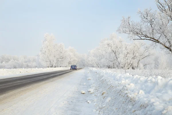 Car on a winter road in the woods leaving afar — Stock Photo, Image